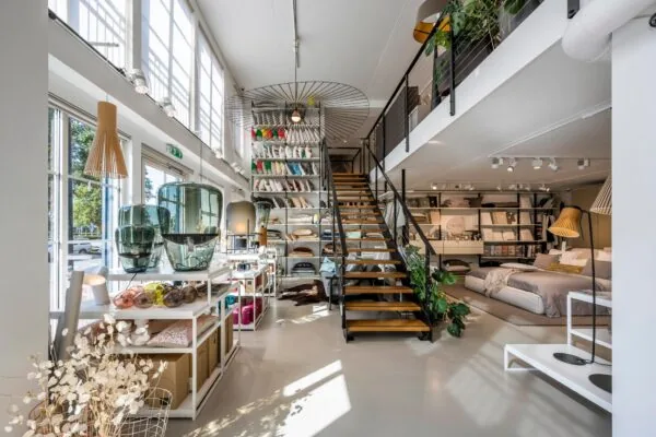 Interieur van een modern ingerichte woonwinkel aan de Oostelijke Handelskade met beddengoed, kussens en designaccessoires.